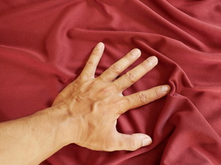 Wall Mural - hands of woman,red silk fabric background