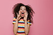 Image of young woman 20s with curly hair shouting or calling, isolated over pink background