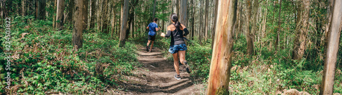Fotomural Young woman and man participating in a trail race through the forest