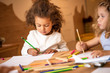 © LIGHTFIELD STUDIOS - adorable multiethnic children drawing with colored pencils in kindergarten