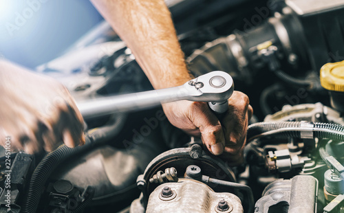 Fotografía Hands of car mechanic in auto repair service with wrench