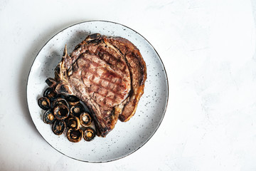 Delicious steak with mushrooms in white plate on isolated background. Copy space.