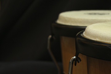 pair of bongos from the right side against a dark background and a dimmer exposure