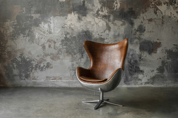 Loft interior mock up photo. Gray textured wall with leather armchair. Background photo with copy space for text. Horizontal