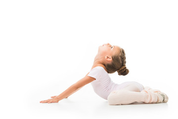 Wall Mural - side view of little kid doing gymnastics exercises isolated on white background