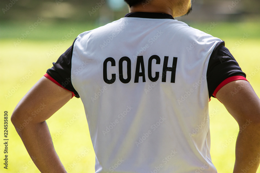 Back view of male soccer or football coach in white shirt  display picture 1