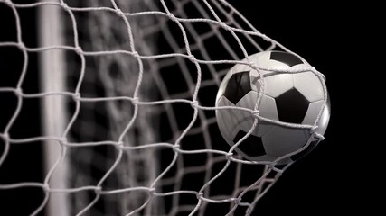Beautiful soccer ball flies into net on a black background. In slow motion