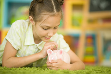 Poster - Portrait of beautiful girl with a piggy bank