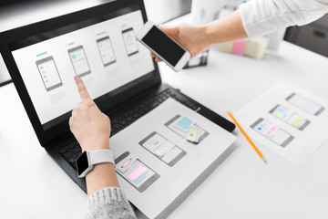 app design, technology and business concept - web designers or developers with laptop computer and s