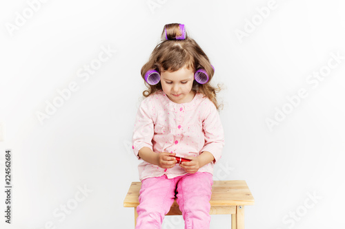 Beautiful Little Girl With Curlers On Her Head Looking At Camera