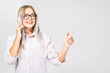 © denis_vermenko - Portrait of a smiling casual very beautiful woman holding smartphone over white background and pointing finger away.