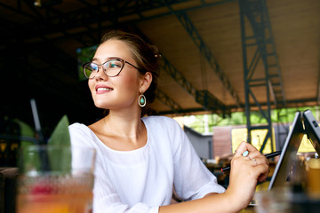 Freelancer mixed race woman hand pointing with stylus on convertible laptop screen in tent mode. Asian caucasian girl using 2 in 1 notebook with touchscreen for drawing and work on design project.