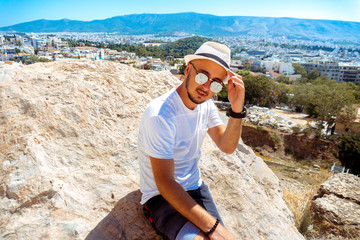 young stylish guy on top of a mountain overlooking the city