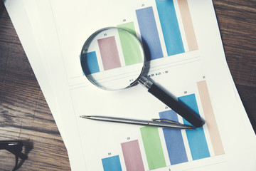 magnifier with pen on graphs