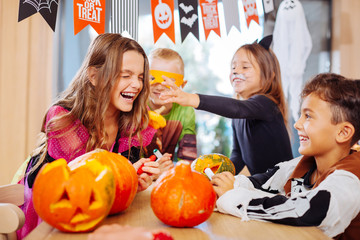 Children laughing. Four children wearing Halloween costumes laughing out loud during the party in spacious light room