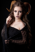 Portrait Of An Attractive Demon Woman With Horns And Curly Hair, Studio Shot For Halloween