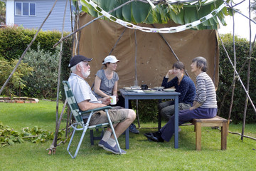 Wall Mural - Jewish Family Sitting in a Sukkah on Sukkoth Feast of Tabernacles Jewish Holiday