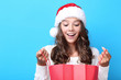 © 5second - Beautiful girl in santa hat holding red shopping bag on blue background
