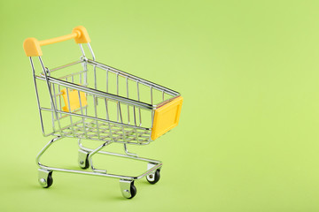 Wall Mural - Shopping cart on green background