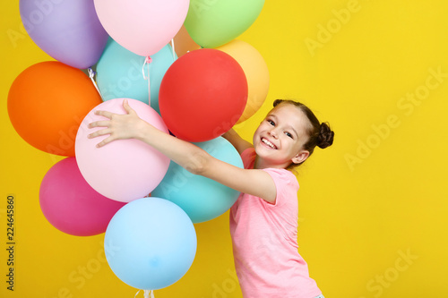 Fotografie, Obraz Beautiful young girl with colored balloons on yellow background