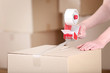 © 5second - Female hands packaging cardboard box with dispenser