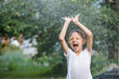 © altanaka - Happy little boy pouring water from a hose.