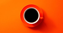 From Above View Of Cup With Black Coffee Placed On Orange Background