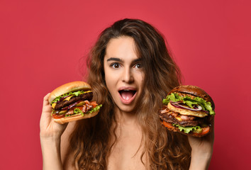 Woman hold two big beef burger sandwich and huge cheeseburger comparing with hungry mouth happy shouting on pink red 