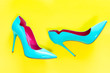 © 18042011 - Blue high heels glassy shoes on yellow background, top view