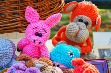 Knitted colorful toys of different animals in a street souvenir shop.