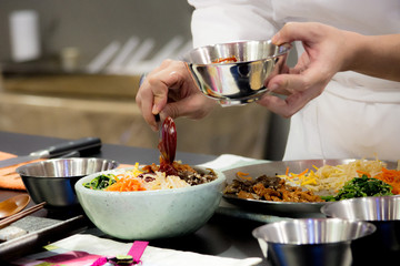 Wall Mural - Bibimbap, Korean food, Chef preparing food, meal, chef cooking in kitchen