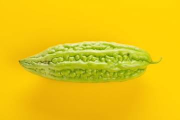 fresh green bitter melon on a yellow background