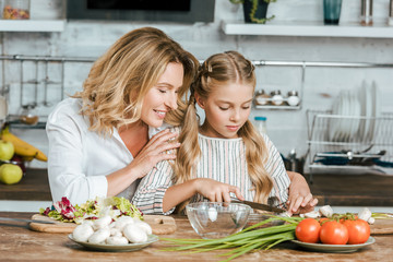 Wall Mural - happy adult mother teaching her little daughter how to cook