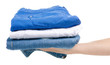 © Kabardins photo - A stack of jeans clothes in hand on a white background isolation