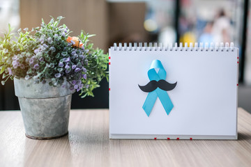 Prostate Cancer Awareness month (November), light Blue Ribbon on white paper for supporting people living and illness. Men Healthcare and World cancer day concept with copy space for your text