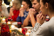 © Syda Productions - holidays and religious concept - close up of friends having christmas dinner and praying before meal