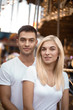 © Sunrise Team - Cheerful loving couple walking outdoors in the amusement park posing.