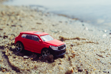 Wall Mural - red car by the sea on the sand, a trip to the sea by