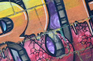 Wall Mural - Fragment of graffiti drawings. The old wall decorated with paint stains in the style of street art culture. Colored background texture in warm tones