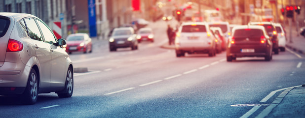 Canvas Print - Cars moving on the road in city in late evening. View to the traffic with trafficlights and transport