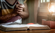 Close up Holy Bible with old woman praying background, christian concept.