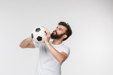 Wall Mural - Young soccer player with ball in front of white studio background