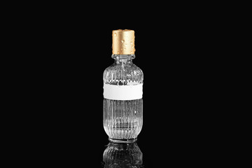 Bottle of perfume and water drops on black background