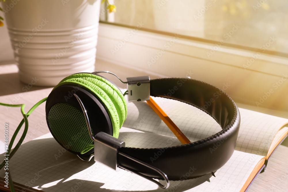 Open notebook and headphones on windowsill