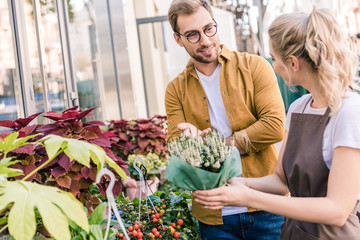 Wall Mural - florist helping customer choosing potted plant at flower shop