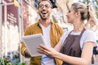 © LIGHTFIELD STUDIOS - laughing florist and customer using tablet at flower shop
