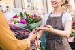 © LIGHTFIELD STUDIOS - cropped image of florist giving beautiful bouquet of chrysanthemums to customer near flower shop