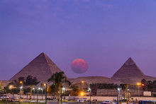 View Of The Great Pyramids Of Giza At Sunset From Giza City With Big Full Moon Rising