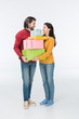 © LIGHTFIELD STUDIOS - smiling couple with wrapped gifts looking at each other isolated on white