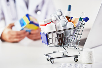 Mini shopping cart full of medicines in pharmacy